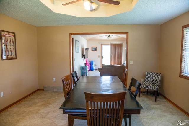 dining room with ceiling fan and a textured ceiling