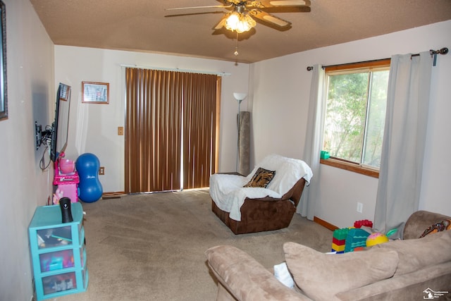 interior space with carpet flooring, a ceiling fan, baseboards, and a textured ceiling