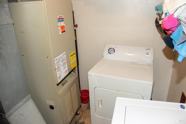 washroom featuring heating unit, separate washer and dryer, and laundry area