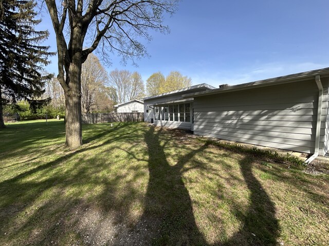 6735 Bayview Dr, Coloma, MI 49038 - view of side of home with a yard and fence