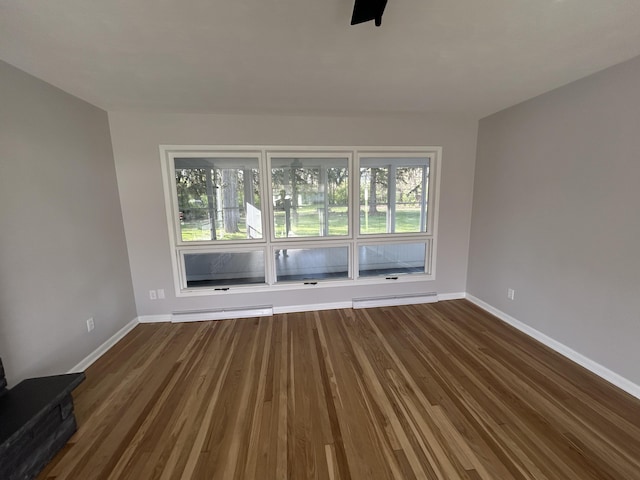 6735 Bayview Dr, Coloma, MI 49038 - unfurnished room with baseboards, a baseboard radiator, and dark wood-type flooring