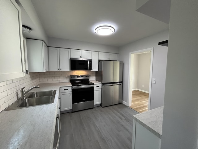 6735 Bayview Dr, Coloma, MI 49038 - kitchen featuring wood finished floors, stainless steel appliances, a sink, and tasteful backsplash