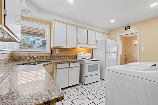 kitchen featuring washer / dryer, white appliances, white cabinetry, under cabinet range hood, and a sink