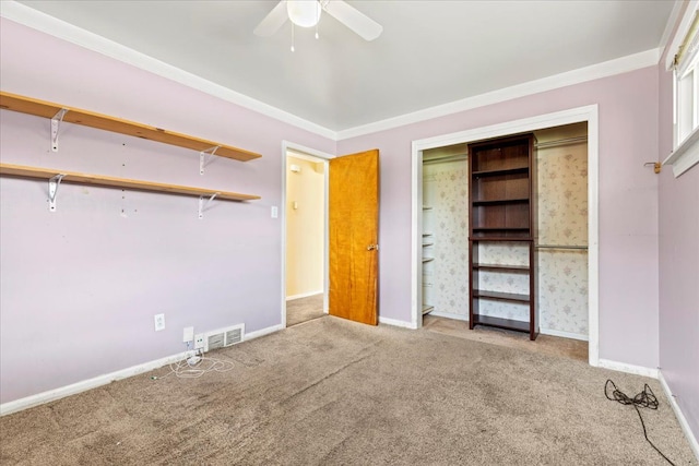 unfurnished bedroom featuring carpet floors, baseboards, ornamental molding, and visible vents