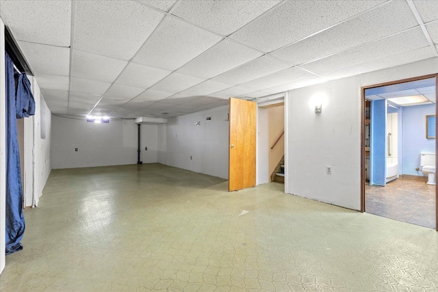 finished below grade area featuring stairs and a drop ceiling