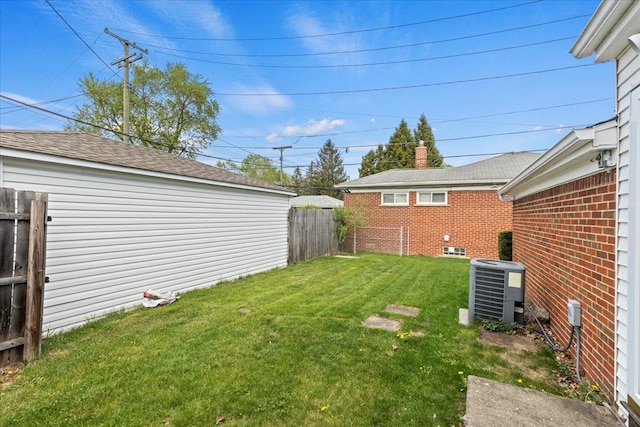 view of yard featuring central AC unit and fence