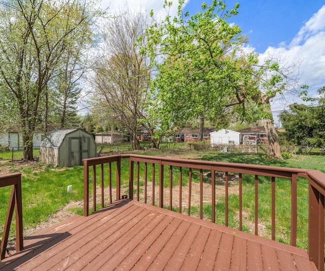 deck featuring a storage unit, an outdoor structure, fence, and a yard