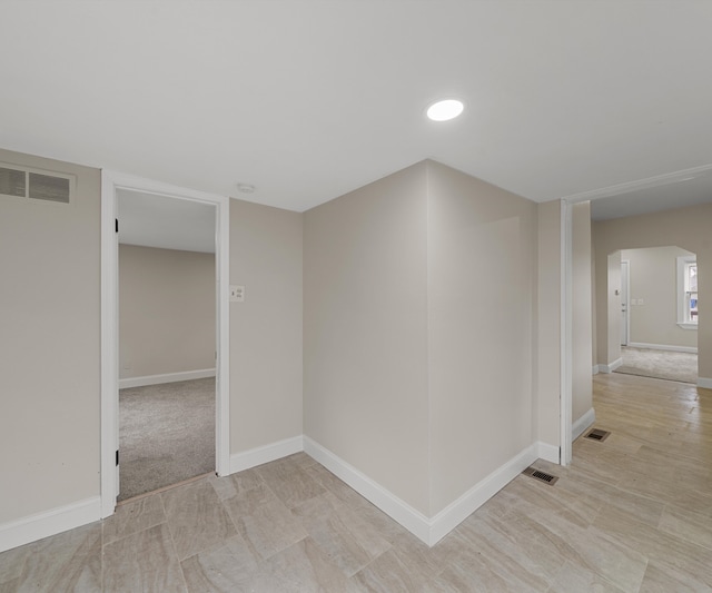 spare room with arched walkways, baseboards, and visible vents