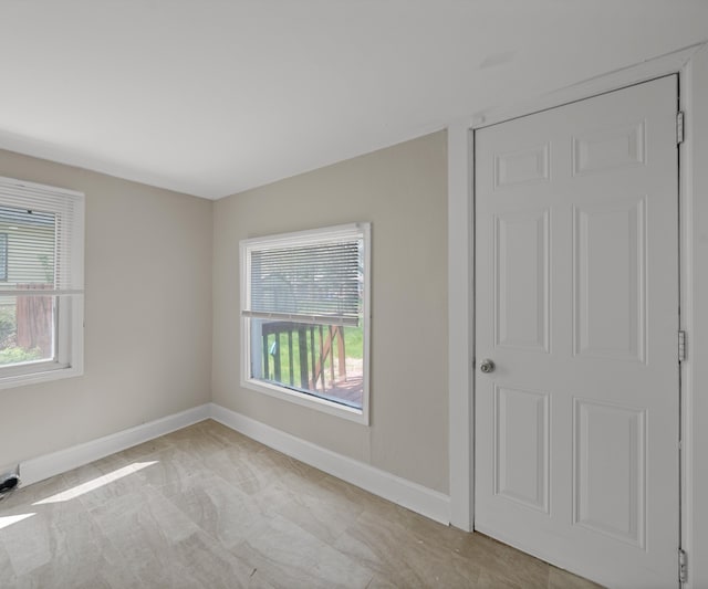 spare room with baseboards