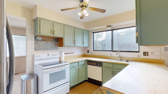 kitchen featuring white appliances, ceiling fan, light countertops, green cabinetry, and a sink