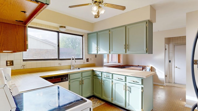 kitchen with green cabinetry, a sink, white appliances, light countertops, and a peninsula