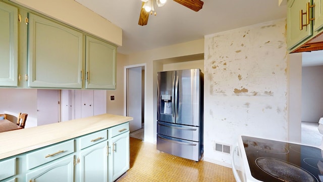 kitchen with visible vents, ceiling fan, stainless steel fridge, light countertops, and green cabinets
