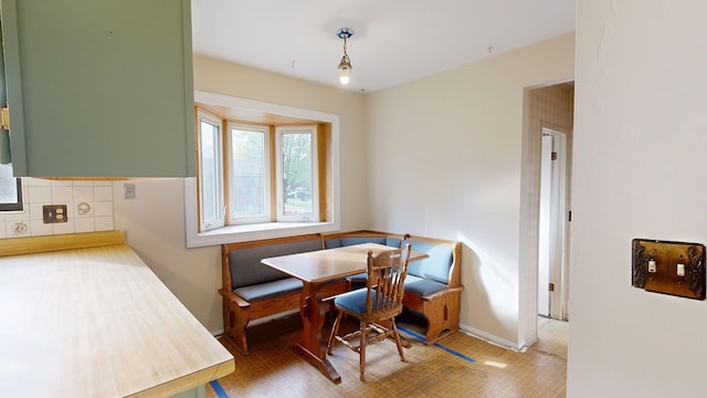 dining space featuring baseboards and light floors