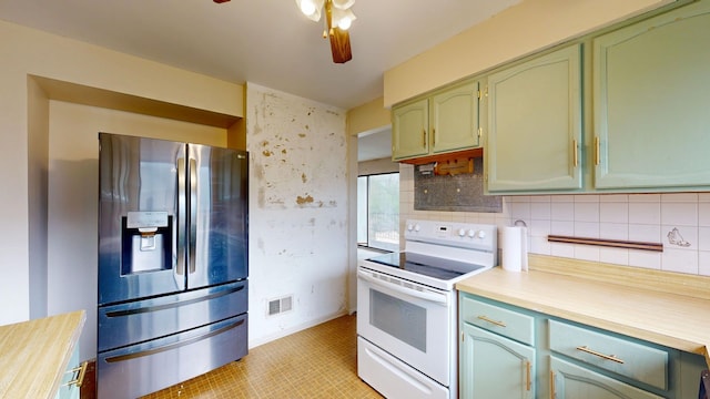 kitchen with stainless steel fridge, green cabinets, white range with electric cooktop, and light countertops