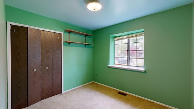 unfurnished bedroom with carpet floors, baseboards, and visible vents