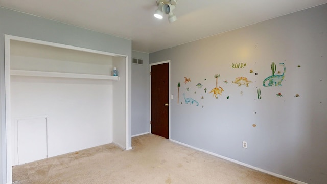 carpeted spare room featuring a ceiling fan, baseboards, and visible vents
