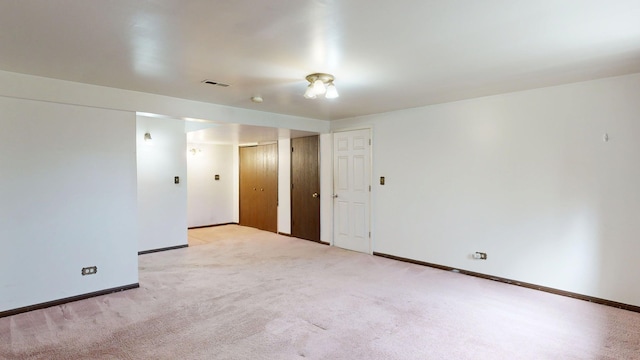 unfurnished room featuring light colored carpet, baseboards, and visible vents