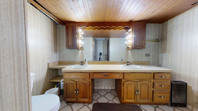 bathroom featuring a sink, wooden ceiling, toilet, and wallpapered walls