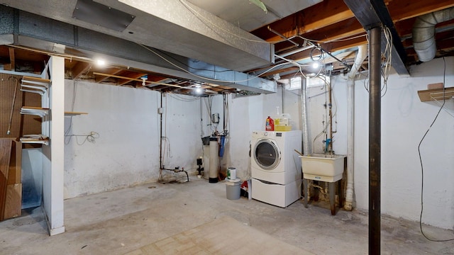 unfinished below grade area with a sink and washing machine and clothes dryer