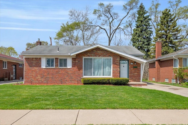 view of front of home featuring a chimney, a front yard, and brick siding