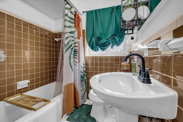full bathroom featuring tile walls, a sink, and shower / tub combo with curtain