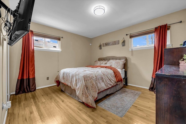 bedroom with baseboards and light wood finished floors