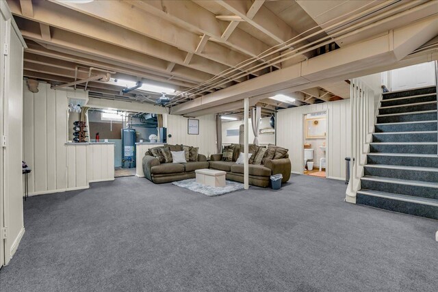 living room with stairway, carpet floors, and gas water heater