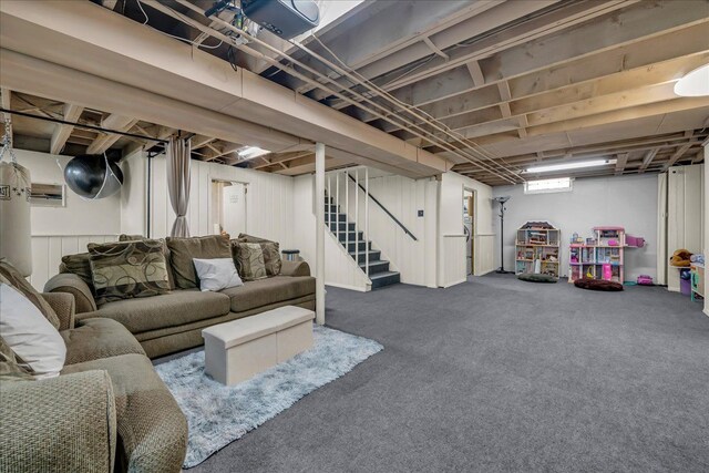 basement featuring a wall mounted air conditioner, carpet, and stairway