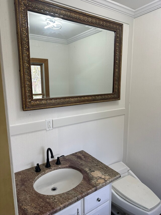 bathroom featuring crown molding, toilet, and vanity