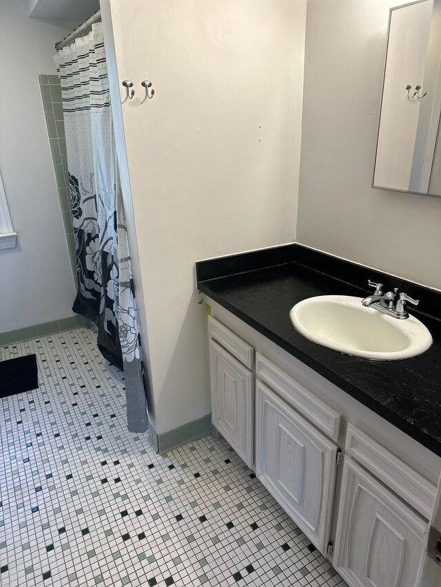 bathroom featuring vanity, baseboards, a shower with shower curtain, and tile patterned floors