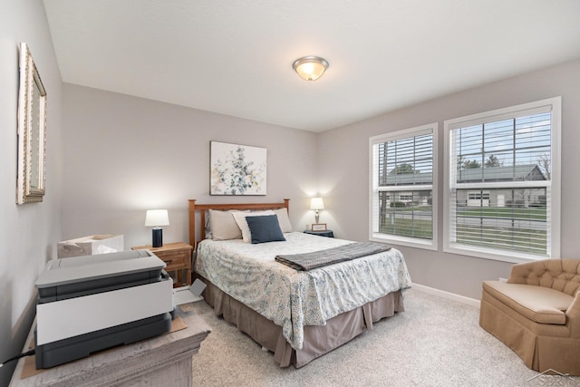 bedroom featuring baseboards and light colored carpet