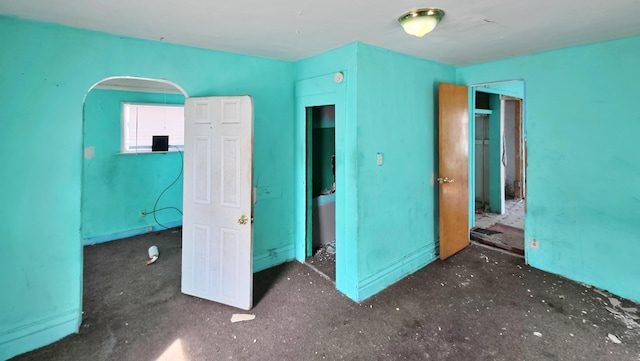 unfurnished bedroom with arched walkways