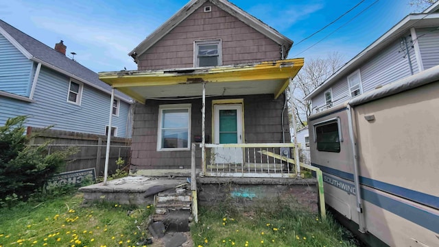 view of front of home featuring a porch and fence