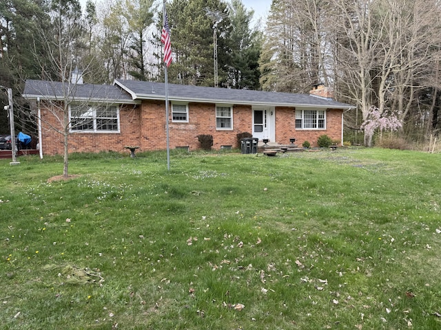 back of house featuring brick siding, a yard, and a chimney