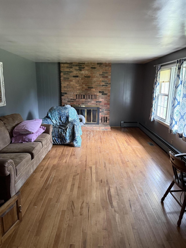 living room with a fireplace, baseboard heating, and hardwood / wood-style floors
