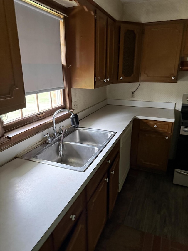 kitchen featuring a sink, light countertops, white dishwasher, and electric stove