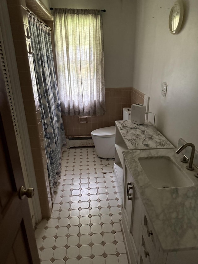full bathroom featuring wainscoting, curtained shower, tile patterned floors, vanity, and toilet
