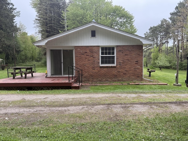 6411 Custer Rd, Carsonville, MI 48419 - rear view of property featuring a deck, a yard, and brick siding