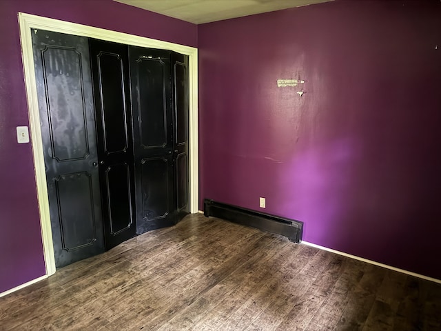 6411 Custer Rd, Carsonville, MI 48419 - unfurnished bedroom with a baseboard heating unit, wood finished floors, and a closet