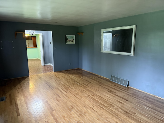 6411 Custer Rd, Carsonville, MI 48419 - unfurnished room with wood-type flooring, a chandelier, and baseboards
