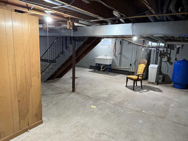 6411 Custer Rd, Carsonville, MI 48419 - unfinished below grade area with stairway, a water pressure tank, a sink, concrete block wall, and electric water heater