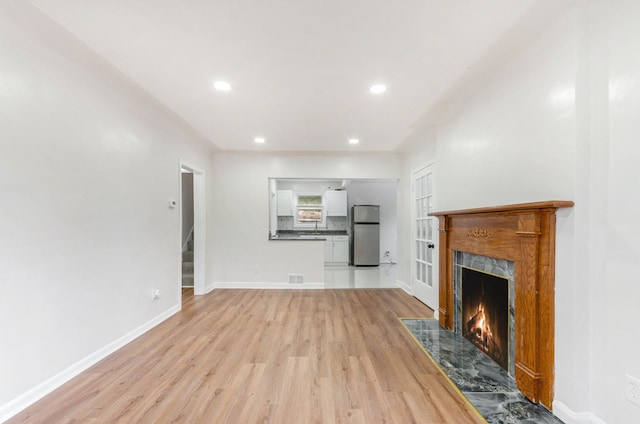 18900 Asbury Park, Detroit, MI 48235 - unfurnished living room featuring a premium fireplace, light wood finished floors, stairs, and recessed lighting