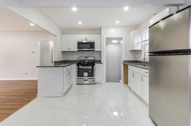 18900 Asbury Park, Detroit, MI 48235 - kitchen featuring a peninsula, tasteful backsplash, dark stone countertops, white cabinets, and appliances with stainless steel finishes