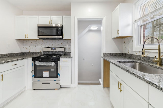18900 Asbury Park, Detroit, MI 48235 - kitchen featuring a sink, white cabinetry, dark stone countertops, backsplash, and stainless steel appliances