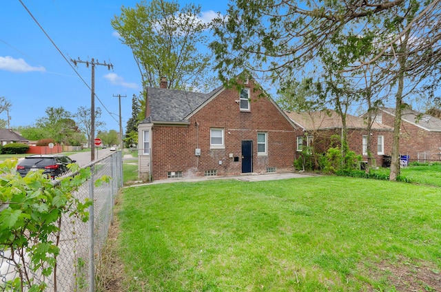 18900 Asbury Park, Detroit, MI 48235 - rear view of house with a lawn, a chimney, brick siding, a shingled roof, and a fenced backyard