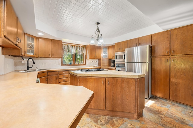 kitchen with a center island, light countertops, a sink, stone finish flooring, and appliances with stainless steel finishes
