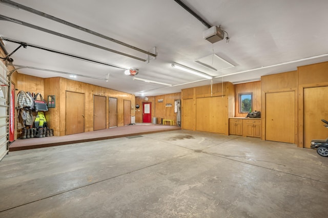 garage with wood walls and a garage door opener