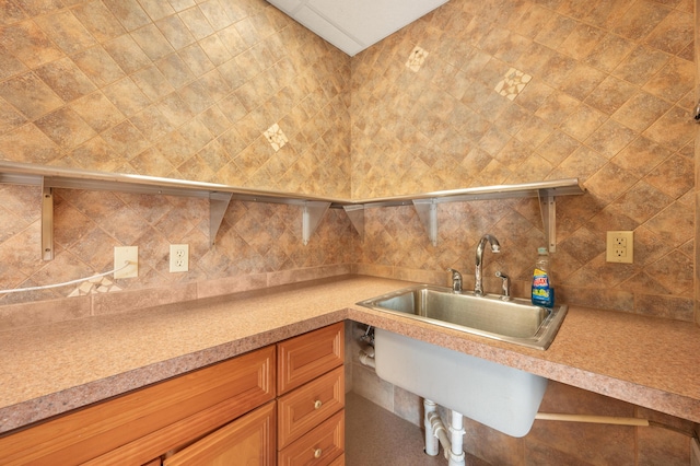 interior space with a sink, light countertops, decorative backsplash, and wet bar