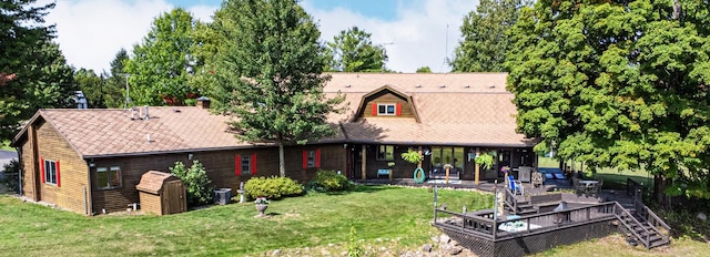 rear view of property featuring a lawn and stairway
