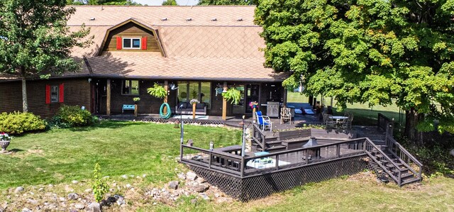 back of property featuring a yard, a deck, and stairs